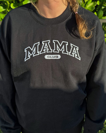 Close-up of the white outline MAMA CLUB embroidery on the black crewneck