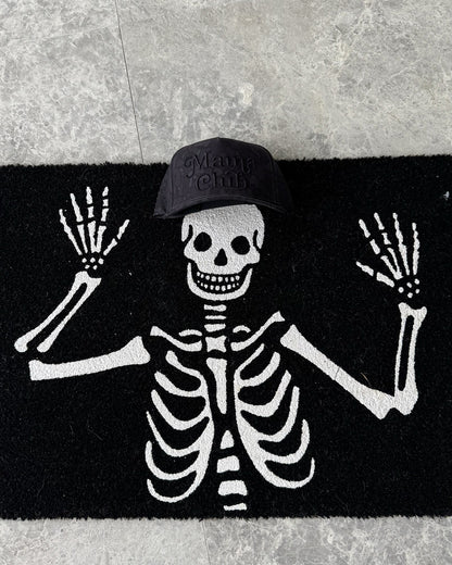 Mama Club black camo trucker on a skeleton Halloween doormat