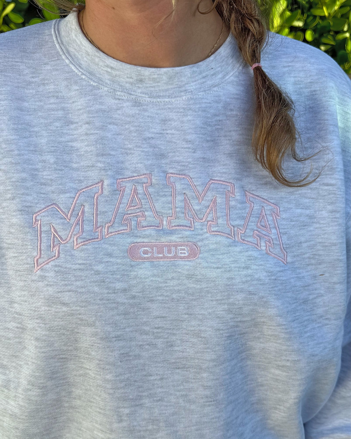 Close-up of the blush pink outline MAMA CLUB embroidery on the heather grey crewneck