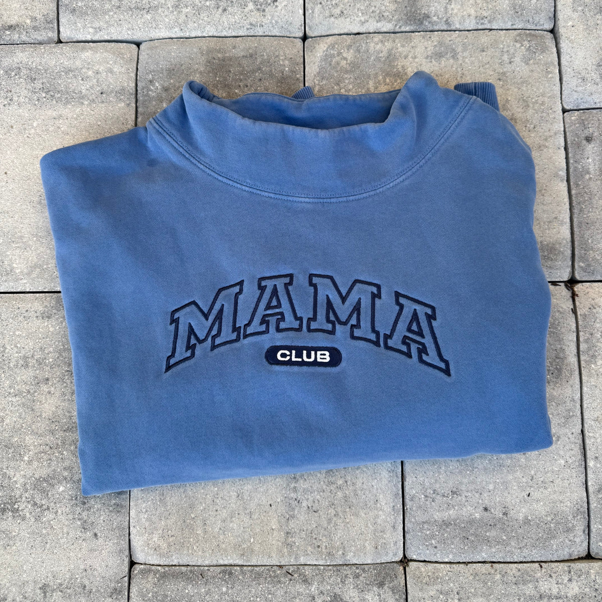Blue Mama Club embroidered mock neck, photographed flat on stone from the Call Her Mama photoshoot