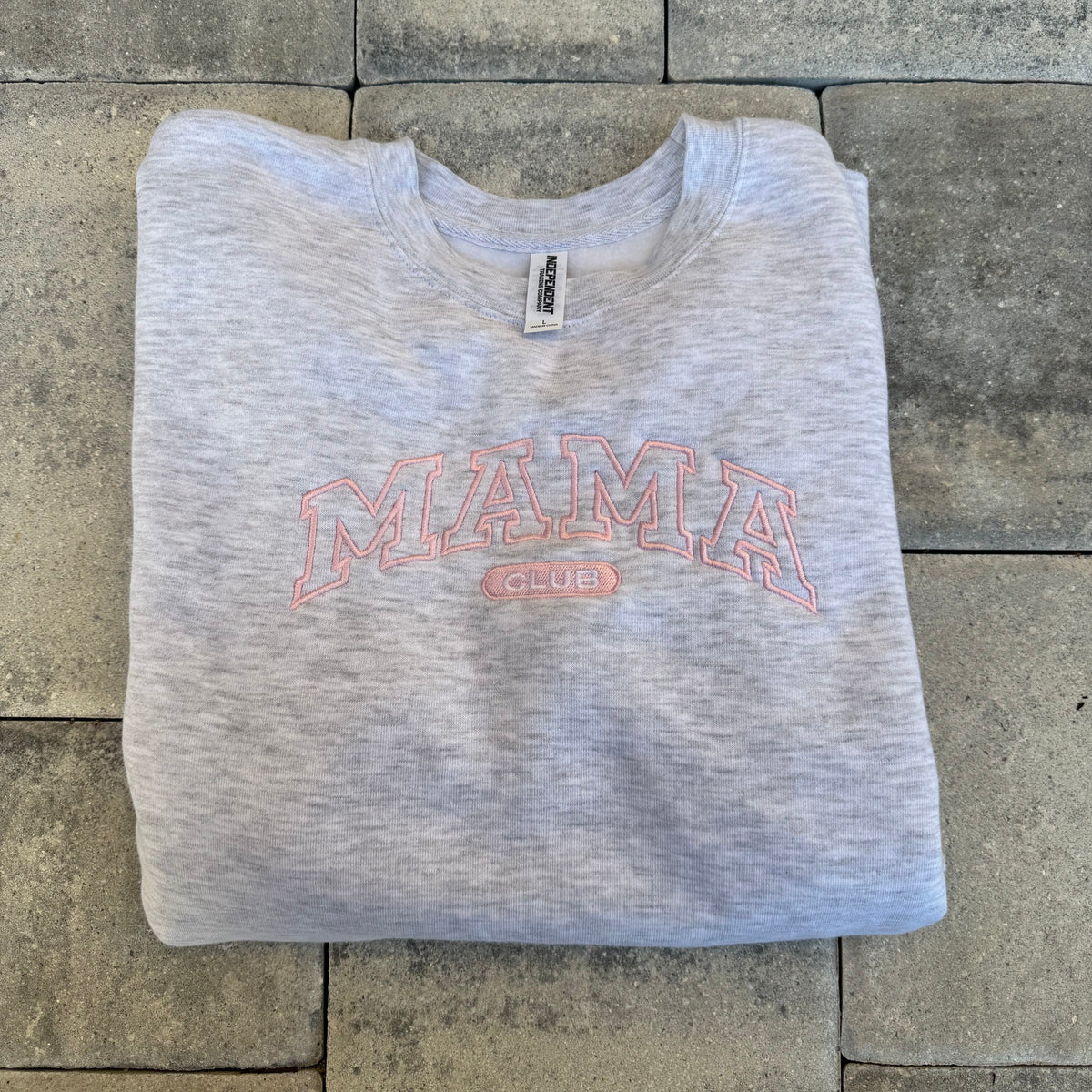 Grey Mama Club crewneck with pink embroidery, photographed flat on stone from the Call Her Mama photoshoot