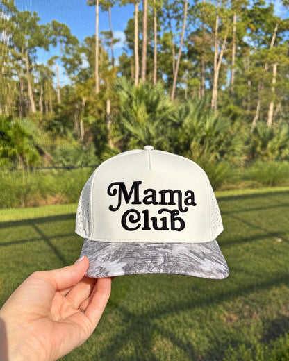Mama Club white and grey camo trucker held outdoors